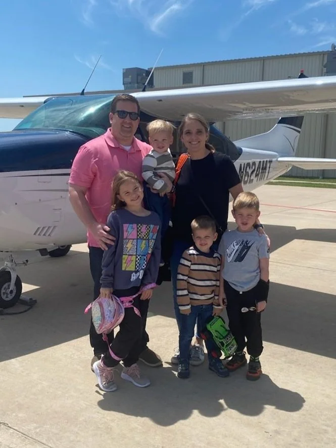 The Hans family standing by a small airplane